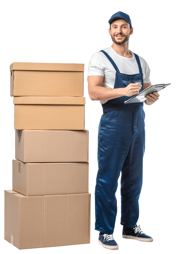 Préposé enbleu portant une chemise blanche et salopette bleue, tenant un carnet, à côté d’une pile de cartons d’emballage.
